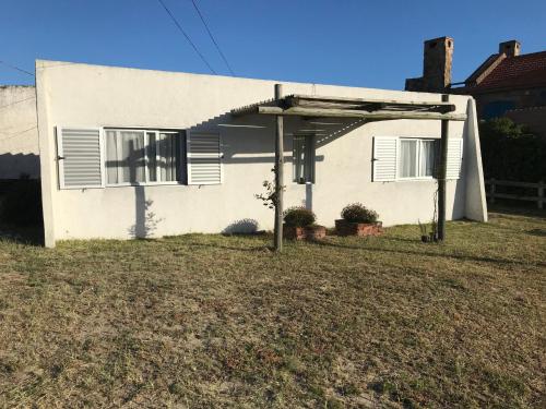 una casa blanca con toldo delante de ella en Conaguademar, en La Paloma