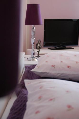a bedroom with a bed with a lamp and a tv at Koral in Koszalin