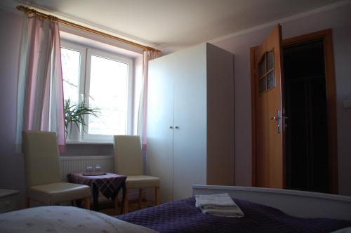 a bedroom with a bed and two chairs and a table at Koral in Koszalin