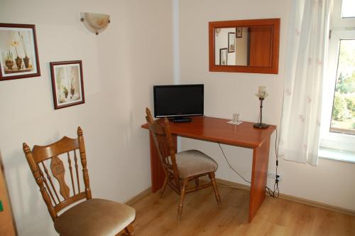 a desk with a computer and two chairs in a room at Koral in Koszalin