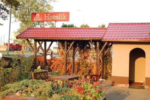 a garden pavilion with a table and benches in a garden at Koral in Koszalin