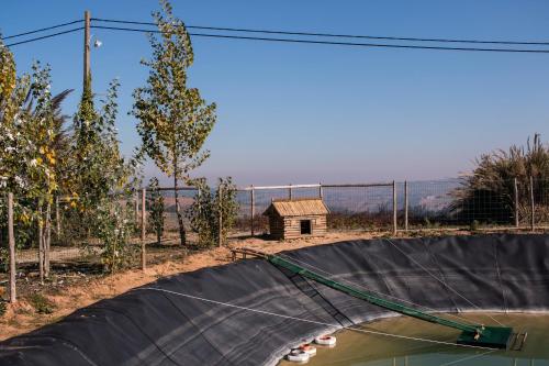 a black tarp over a pool of water with a building at Entre Vinhas & Mar in Óbidos