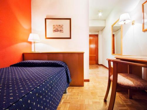 1 dormitorio con 1 cama, 1 mesa y 1 silla en Hotel Alcarria en Guadalajara