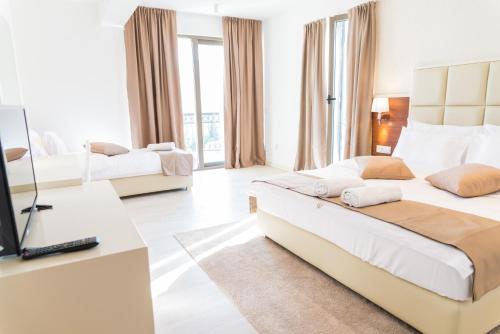 a hotel room with two beds and a television at Hotel Kadmo by Aycon in Budva