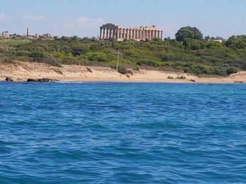a large body of water with a building in the background at Casa Waida in Marinella di Selinunte