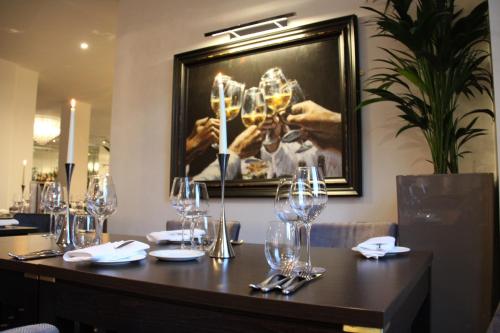 a table in a restaurant with wine glasses on it at Belgrave Sands Hotel & Spa in Torquay