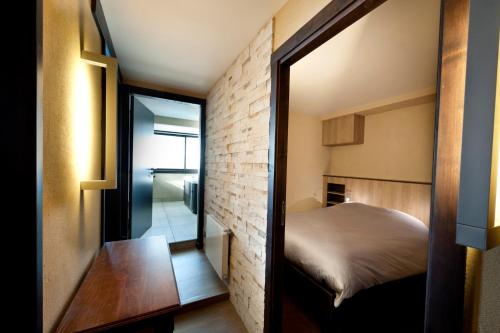 une petite chambre avec un lit et un miroir dans l'établissement Névés Appartements VTI, à Val Thorens