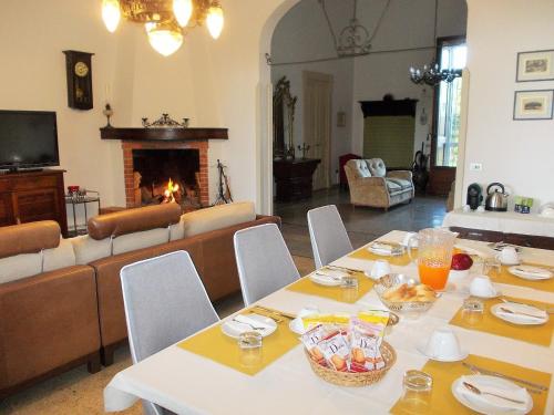 een woonkamer met een tafel en een open haard bij B&B Villa I 2 Leoni in Lecce