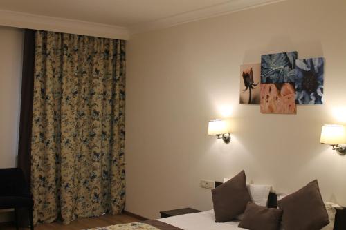 a hotel room with a bed and a curtain at Non-stop hotel in Boryspilʼ