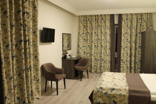 a hotel room with a bed and a desk at Non-stop hotel in Boryspilʼ