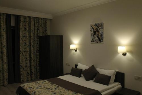 a hotel room with a bed and two lamps at Non-stop hotel in Boryspilʼ