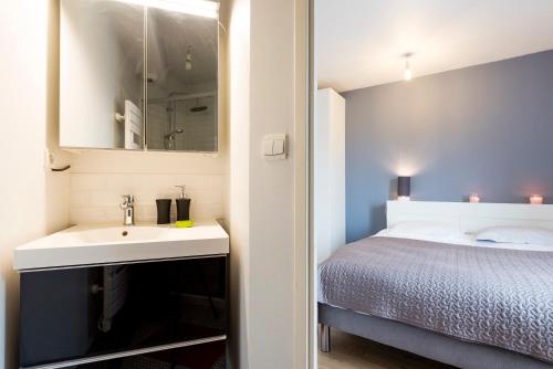une chambre avec un lit, un lavabo et un miroir dans l'établissement Le Patte d'Oie, à Toulouse