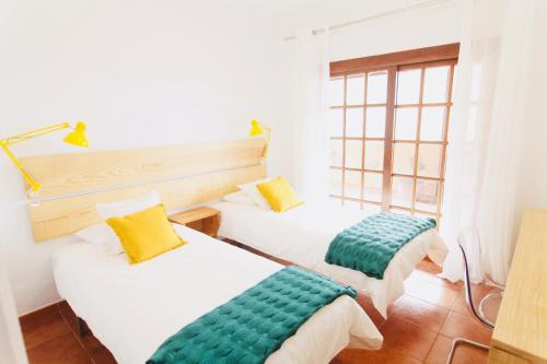 two beds in a room with a window at La Casa Del Valle in Agaete