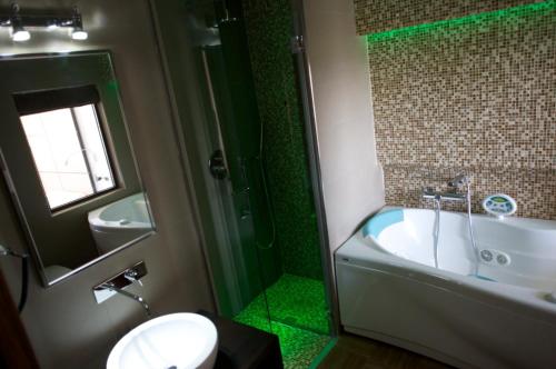 a bathroom with a tub and a toilet and a sink at Hotel Cimarosa in Naples