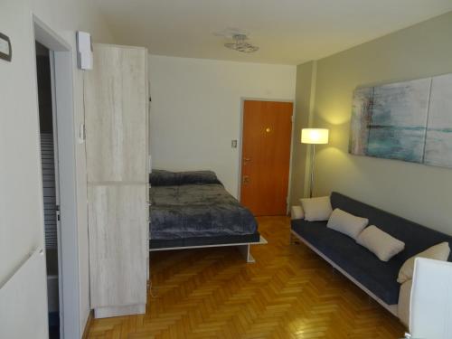 ein Schlafzimmer mit einem Bett und einem Sofa in einem Zimmer in der Unterkunft Apartamento en San telmo in Buenos Aires