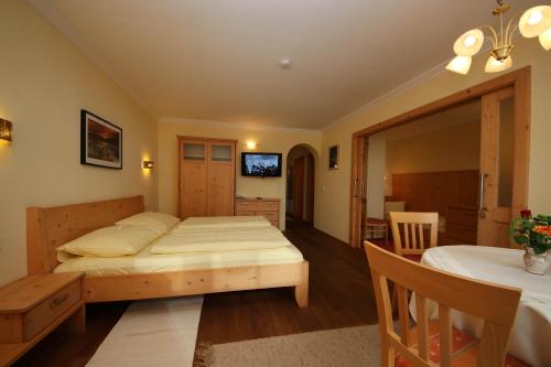 a bedroom with a bed and a dining room at Forellenstube in Lofer