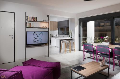 a living room with a purple couch and a kitchen at Elysium Boutique Apartments in Athens