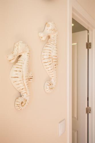 two white seahorses hanging on a wall at CASAL RIQUEZO T1 - Serra da Pescaria - NAZARÉ in Nazaré