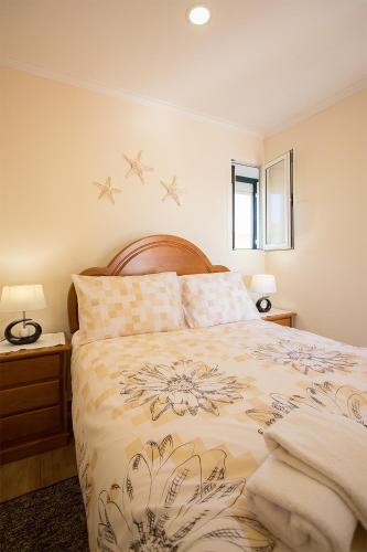 a bedroom with a bed and two night stands and two lamps at CASAL RIQUEZO T1 - Serra da Pescaria - NAZARÉ in Nazaré