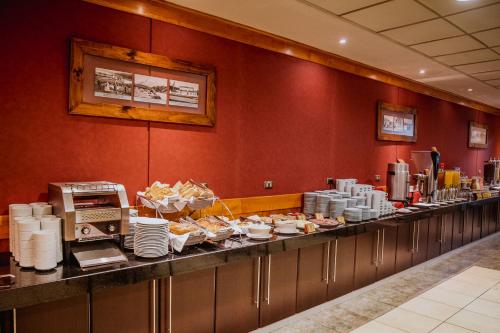 a counter with a variety of food items on it at Hotel Diego de Almagro Punta Arenas in Punta Arenas
