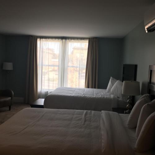 a hotel room with two beds and a window at Talbott Tavern and Inn in Bardstown