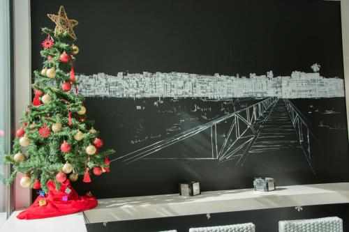 a christmas tree on a table with a picture of a bridge at La Pasajera Hostal Boutique in Conil de la Frontera