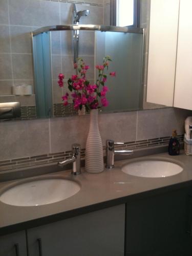 a bathroom with two sinks with a vase with flowers in it at Fener Hotel Café & Kahvalti in Cesme