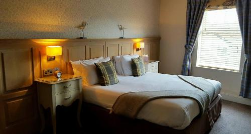 a bedroom with a bed and a lamp at Queens Head Inn & Restaurant in Hawkshead