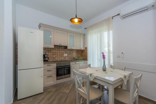 a kitchen with a table and a white refrigerator at Bed & Breakfast Daniela in Veleniki