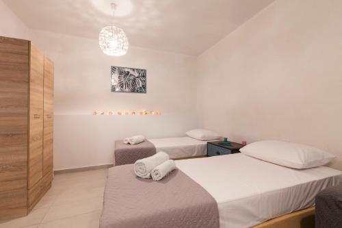 Cette chambre comprend deux lits et un lustre. dans l'établissement Spianada Studios by Konnect, Old Corfu Town, à Corfou