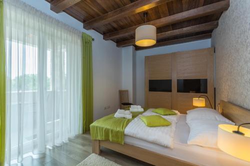 a bedroom with a large bed and a large window at Bed & Breakfast Daniela in Veleniki