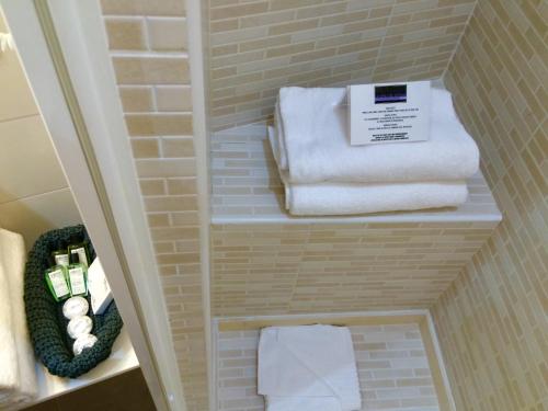 een badkamer met handdoeken op planken in een kamer bij La Cupola del Vaticano in Rome