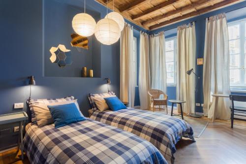 2 camas en un dormitorio con paredes azules en COSY APARTMENT 2 MINUTES FROM DUOMO en Milán
