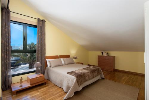 a bedroom with a bed and a large window at Arpaso in Costa Teguise