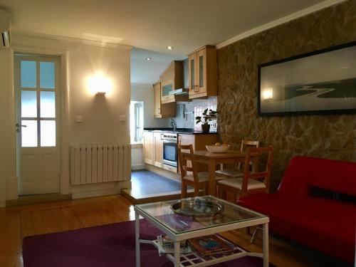Una sala de estar con un sofá rojo y una mesa. en Flores, en Lisboa