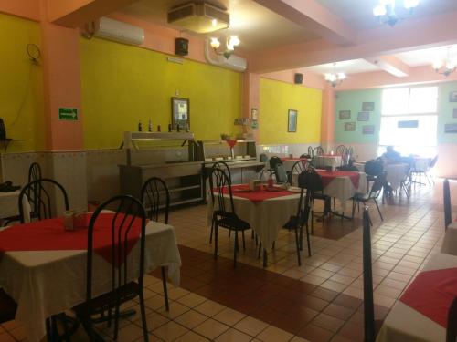 a restaurant with tables and chairs and yellow walls at Hoteles Santa Regina in Chihuahua