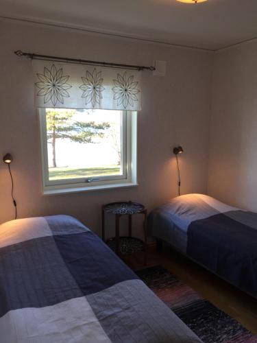 a bedroom with two beds and a window at Villa Solstrand in Fagerlund