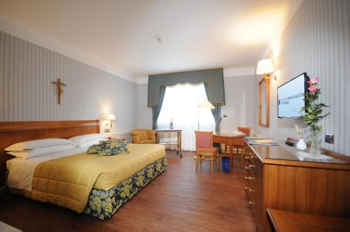 a hotel room with a bed and a desk at Hotel Centro di Spiritualità Padre Pio in San Giovanni Rotondo