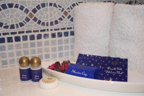 a bathroom counter with a shelf with towels and products at Pine Tree Apartments - Praia da Coelha - Albufeira in Albufeira