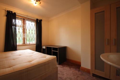 1 dormitorio con cama, lavabo y ventana en Draycott en Londres