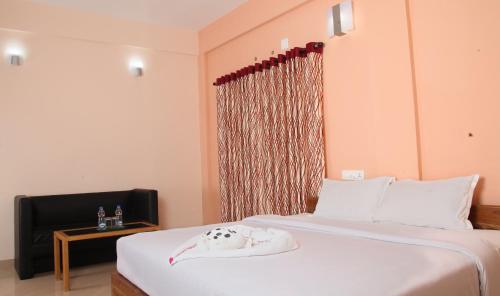 a bedroom with a large bed and a window at Pine Tree Munnar in Munnar