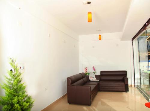 a living room with a couch and a christmas tree at Pine Tree Munnar in Munnar