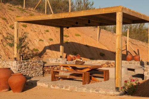 a wooden pavilion with a table and a stone wall at Villas Toscanas in Limache