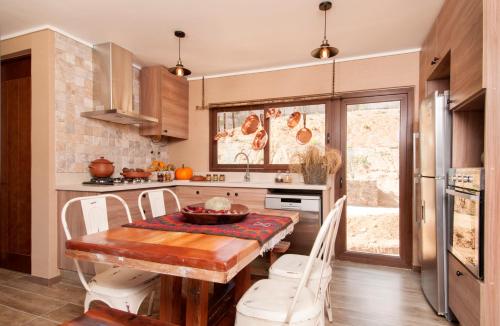 a kitchen with a wooden table and white chairs at Villas Toscanas in Limache