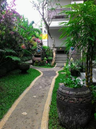 a garden with a walkway in front of a house at ThreeWin Homestay in Ubud