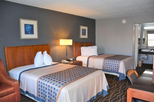 a hotel room with two beds and a chair at Travelodge by Wyndham Walterboro in Walterboro