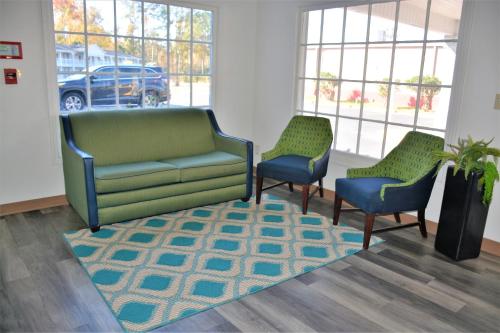 a waiting room with two chairs and a couch and a rug at Travelodge by Wyndham Walterboro in Walterboro