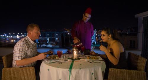 a group of people sitting at a table eating food at Palais Zahia Hotel & Spa in Tangier