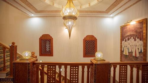 a staircase with a chandelier and a painting on the wall at Palais Zahia Hotel & Spa in Tangier