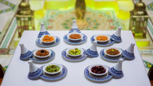 a table with blue and white vases and bowls of food at Palais Zahia Hotel & Spa in Tangier